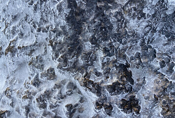Lava stone covered by layer of an ice texture close up. Winter in Teide National Park. Tenerife, Canary Islands,Spain. Selective focus.