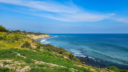 a beautiful spring landscape at Point Dume beach with blue ocean water, lush green trees and...