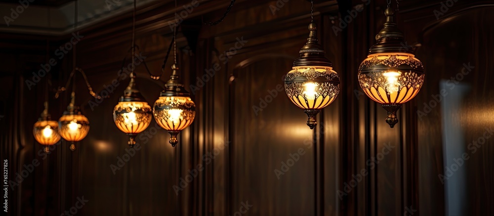 Poster this image shows a close-up view of a series of lights suspended from the ceiling in a row.