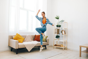 Joyful Woman Jumping with Music in a Relaxing Home Lifestyle