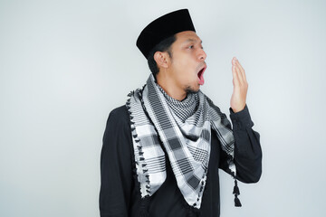 asian muslim man covering his mouth with hand or bad breath, wearing Arab turban sorban on isolated...