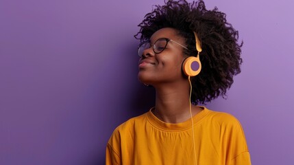 beautiful brunette woman with curly hair listening to music with headphones on purple background in high resolution and high quality hd