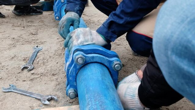 Workers installing water supply pipeline system, close up