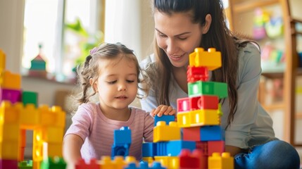 A mom is helping her child build a tower with blocks but it keeps falling down. She reminds them that trying again is part of the fun and that their mistakes help them figure