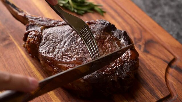 slicing tomahawk steak with knife