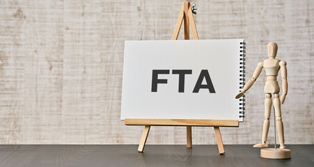 There is notebook with the word FTA. It is an abbreviation for Free Trade Agreement as eye-catching image. - obrazy, fototapety, plakaty