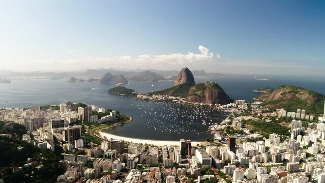 Aerial Beautiful View Of Sugarloaf Mountain In Sea, Drone Flying Backwards Over Buildings In City On Sunny Day - Rio de Janeiro, Brazil