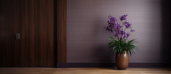 A houseplant in a flowerpot sits in a wooden vase filled with purple flowers next to a hardwood door in the room