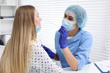 Laboratory testing. Doctor taking sample from patient's nose with cotton swab in hospital