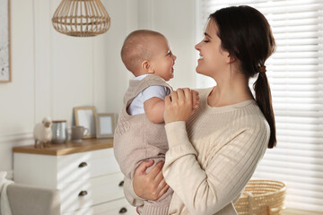 Happy young mother with her baby at home. Space for text