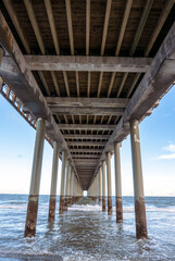 Pier stretches into the sea, framing coastal architecture and ocean.