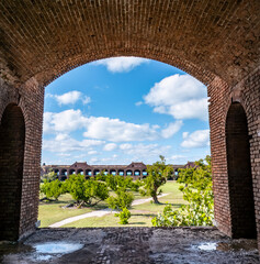 View through an open archway in Fort Jefferson on Dry Tortugas National Park with a the open courtyard a parade ground in the distance.