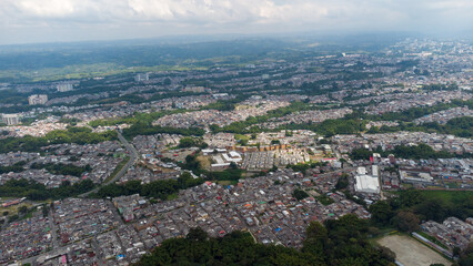 Aerial view of the city of Armenia, Quindío, Colombia. Buildings in the city of Armenia between trees and the green mountains in the background