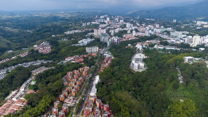 Aerial view of the city of Armenia, Quindío, Colombia. Buildings in the city of Armenia between trees and the green mountains in the background