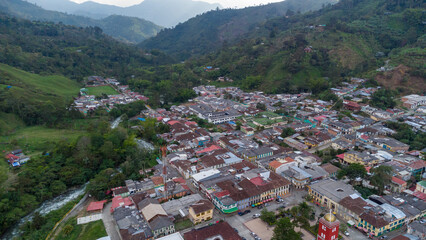 Aerial view of the green mountains and the river in the municipality of Pijao, Quindío, Colombia. Pijao, city without rush. Main park and church of Pijao.