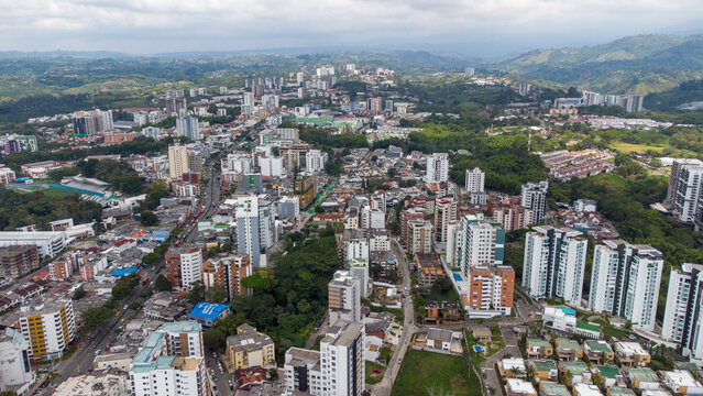 Aerial view of the city of Armenia, Quind&iacute;o, Colombia. Buildings in the city of Armenia between trees and the green mountains in the background