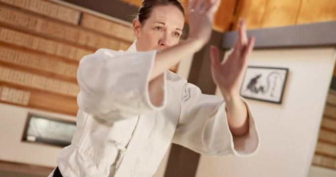 Exercise, aikido or woman learning martial arts in dojo for practice, body movement or self defense. Combat routine, wellness or female person in training workout for fighting, education or class