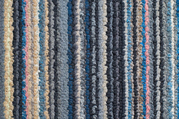 Texture of the woven jute carpet. Natural organic fiber with colorful striped motifs