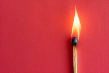 Burning matchstick on a red background