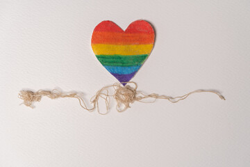 corazón del orgullo gay con fondo blanco e hilos en la parte inferior