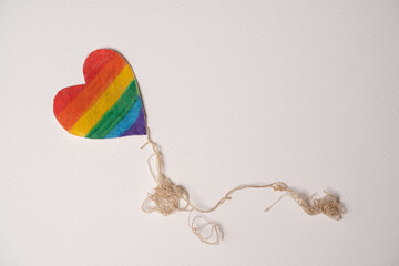 corazón de tela pintada con arcoíris con cola simulada de hilos enredados