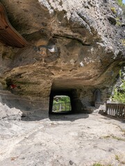 大きな岩をくりぬいて作られたトンネルのあるお寺の参道の情景
