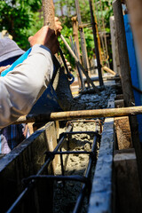 Construction workers pour concrete on cement wall new house