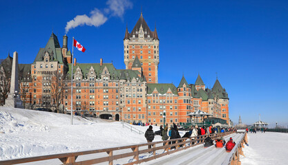 Traditional slide ride in winter in Quebec City with Frontenac Castle on the background, Canada