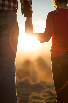 Father daughter holding hands at golden hour
