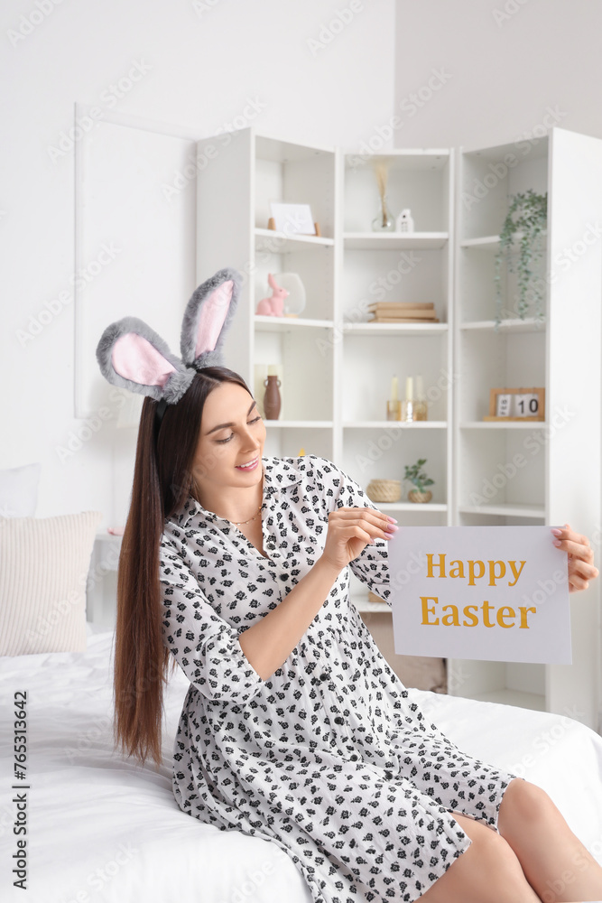 Poster young pregnant woman holding paper with text happy easter in bedroom