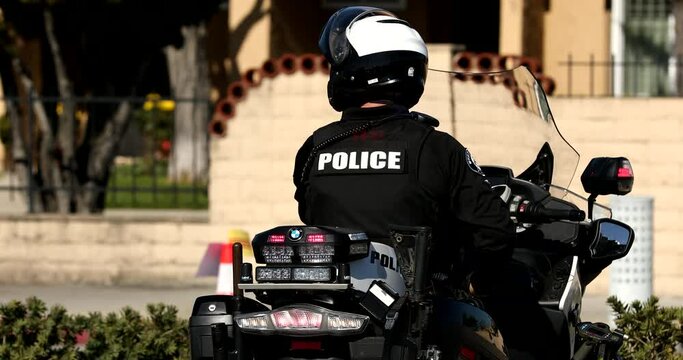 Westminster, California, USA - January 22, 2023: A motorcycle mounted police officer watches over a scene.