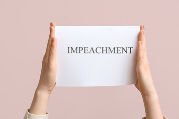 Woman holding IMPEACHMENT picket poster on pink background