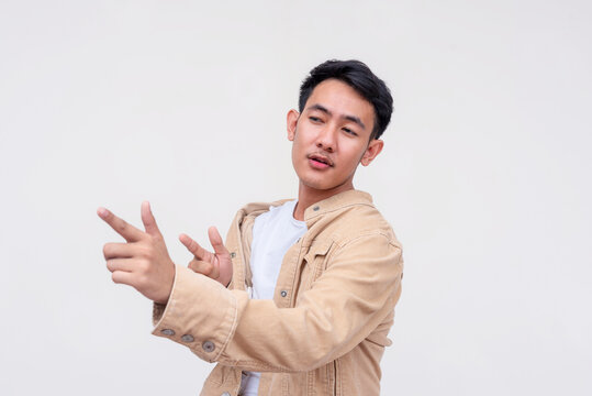 Confident Asian man making finger guns in cool pose on white background