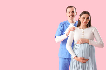 Young pregnant woman and doctor with tablet computer on pink background