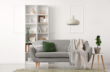 Light interior of living room with sofa and shelving unit