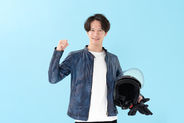 ヘルメットを持ってガッツポーズをする男性