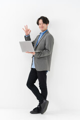 ノートパソコンを持ってサインをする男性