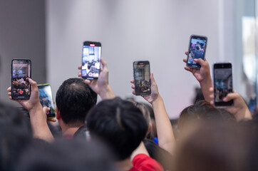 people recording video with smartphone during a concert , party, festival.