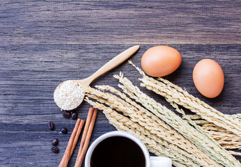 Ears of wheat and egg on wooden table background