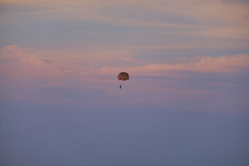 Tourists fly in the sky on a parachute against the sunset near Phu Quoc Island of Vietnam.