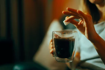 Foto op Plexiglas Hand Adding One Cube of Sugar in her Black Coffee. Person sweetening her drink disregarding the health risks  © nicoletaionescu
