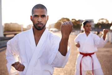Serious people, karate and martial arts with personal trainer for self defense, class or teaching in city street. Man and woman fighter or athlete in fitness training, kata or technique in urban town