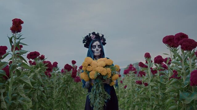 Holiday Day Of The Dead and a masked girl walking and holding flowers