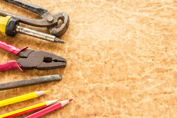 Tools and pencil on old paper background - obrazy, fototapety, plakaty