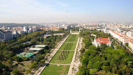 Aerial Shot Of Famous Parque Eduardo Vii In Residential City Against Sky, Drone Flying Forward On Sunny Day - Lisbon, Portugal