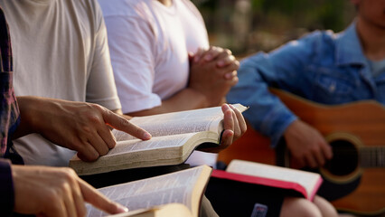 The people read and studied the bible at the park and prayed together. sharing the gospel with a friend. Holy Bible study reading together on Sunday.Studying the Word Of God With Friends. Education. - obrazy, fototapety, plakaty