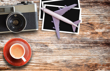 Top view with model plane,retro camera and cup of coffee on wooden table background.