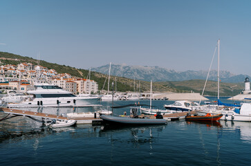 Fototapeta na wymiar Inflatable motor boats stand next to yachts at the marina berths
