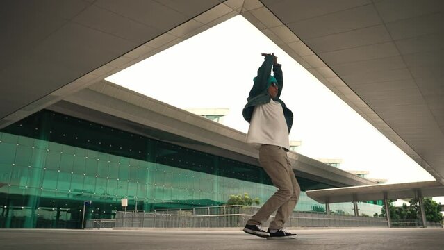 Panorama shot of happy hipster dance together while listen music from headphone at mall. Professional break dancer enjoy perform b boy footstep. Outdoor sport 2024. Modern street dancing. Sprightly.
