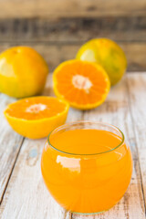Glass of freshly pressed orange juice on wooden table